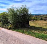 Lands - housing in Jarabina with greenery and a country road under a blue sky.