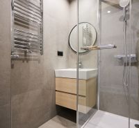 Bathroom in a 2-room apartment with a bathtub, shower, and mirror.