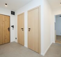 Entrance hallway in a 2-room apartment with wooden doors and tiles.
