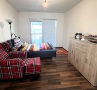 A room in a family house with a comfortable armchair and a bed, and a floor with a wooden decor.