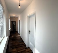 A device in a family house with a wooden decor floor and blinds on the windows.