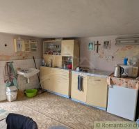 Kitchen unit with a sink, older furniture, and tiles in a family house.
