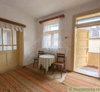 A room in a family house with carpets, a table, and chairs, a space full of light.