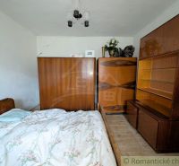 The interior of the family house includes a bed, a wardrobe, and a floor with a wooden decor.