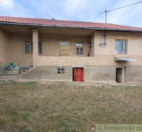 A family house in Nižné Ladičkovce with a veranda and a red roof, grassy yard.