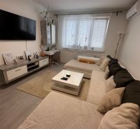 Living room in a 3-room apartment with a sofa, television, and table, floor with wooden decor.