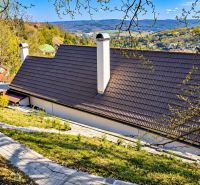 The roof of the cottage in Banská Štiavnica with a picturesque view of the hills and greenery.