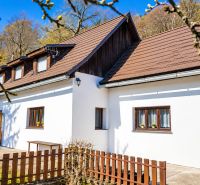 A cottage in Banská Štiavnica with a sloped roof, wooden windows, surrounded by nature.