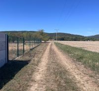 A dirt road in Dulov next to a fence and a large plot, ideal for living.