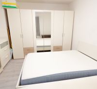 Bedroom in a family house with a large wardrobe, bed, and drawers.