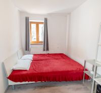 Bedroom in a family house with a window, bed, and shelf.