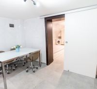 A room in a family house with a white table, chairs, and sliding doors to the laundry room.