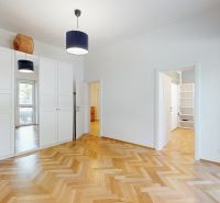 A room with a built-in wardrobe and a floor with a wooden decor in a 4-room apartment.
