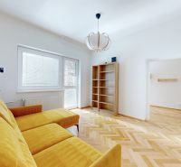 A bright room in a 4-room apartment with a wood-patterned floor and a yellow sofa.