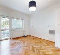 A room with a bright interior and a wooden decor floor in a 4-room apartment.