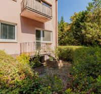 A garden by a 4-room apartment in Bratislava, Ružinov, Bajkalská Street, surrounded by greenery.