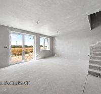 An empty interior of a family house with concrete stairs and large windows.
