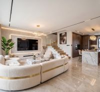 Open space with a kitchen, staircase, and comfortable living room in a family house.