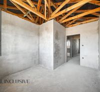 In the interior of a family house with a rough construction and a wooden ceiling beam.