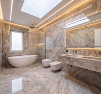 Luxury bathroom with marble tiles, bathtub, and wall-hung toilet in a family house.