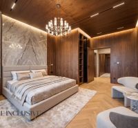 A bedroom in a family house with a wooden decor floor, marble tiles, and an elegant chandelier.