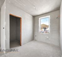 A room in a family house with gray walls, a window, and only basic finishing.