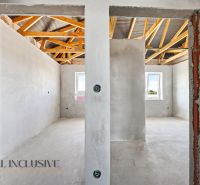 The interior of a family house with plastered walls and an uncovered ceiling.