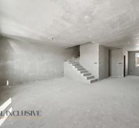 Interior of a family house with concrete stairs and plastered walls.