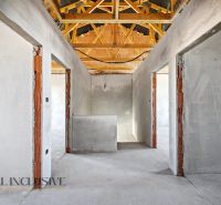 An interior with open spaces and wooden beams in a family house.