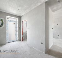 An unfurnished interior with white walls and an entrance door in a family house.