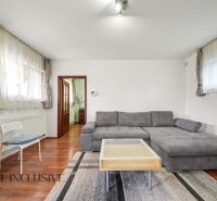Living room with wood-patterned flooring, a sofa, and a coffee table in a family house.