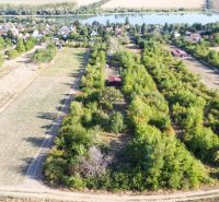 An aerial view of an area with plenty of greenery and a distant lake in Suchá nad Parnou.
