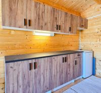 A kitchen unit in a cottage with a wooden decor and white appliances.