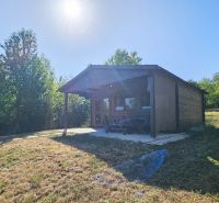 A cottage in Suchá nad Parnou with a grassy plot and a terrace surrounded by lush greenery.