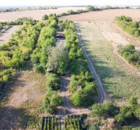 Aerial view of a cottage in the village of Suchá nad Parnou surrounded by nature and fields.