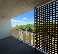 A balcony with a wooden floor and a view of Main Street in Galanta.