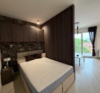 Bedroom in a 2-room apartment, bed, space with separate living area and balcony.