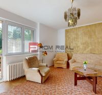 Living room in a 4-room apartment with a wooden decor floor and a comfortable sofa.