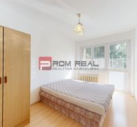 Bright bedroom in a 4-room apartment with wood-patterned flooring and a built-in wardrobe.