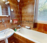 A bathroom with a shower and a bathtub in a 4-room apartment, tiled with brown tiles.