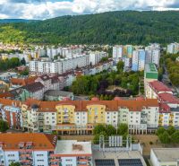 Moyzesova Street in Púchov with apartment buildings and greenery, Commercial spaces.