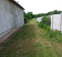 The back part of the building enclosed by a fence in Beladice, suitable for residential plots.