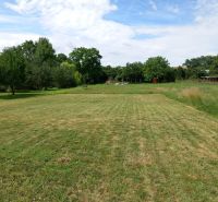 Spacious residential plots in Beladice with grassy areas and trees.