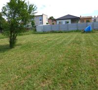 Plots - housing in Beladice with maintained lawn and a tree, houses in the background.