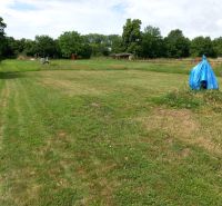 A grassy plot in Beladice suitable for living, surrounded by lush greenery and trees.