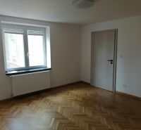 A room with a wooden decor floor and a window in a 2-room apartment.