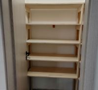 Shelf space in a 2-room apartment with wooden decor doors and flooring.