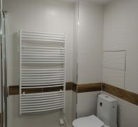 Bathroom in a 2-room apartment, with ceramic tiles and a heating unit on the wall.