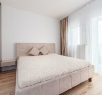 Bedroom with a large bed and a wooden decor floor in a 2-room apartment.