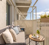 Balcony in a 2-room apartment, comfortable sofa, table, flower pots, relaxing environment.